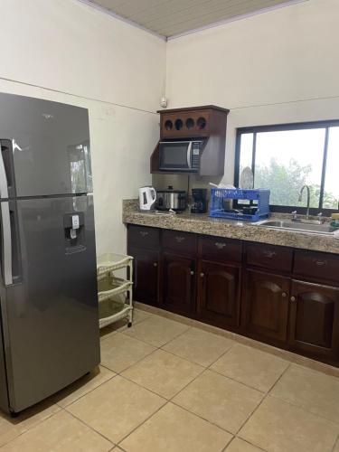 a kitchen with a stainless steel refrigerator and a sink at Casa de montaña con vista al océano pacífico in Magallanes