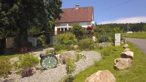 a clock in a garden in front of a house at Ferienhaus Mitzi in Floing