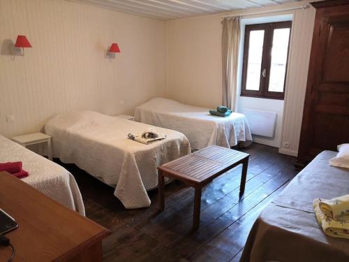 a room with two beds and a table and a window at Appart Talloires proche plages et commerces avec salle de jeux in Talloires