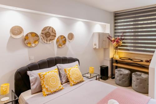 una camera da letto con un letto con cuscini gialli e bianchi di Sweet greek memories C ad Atene