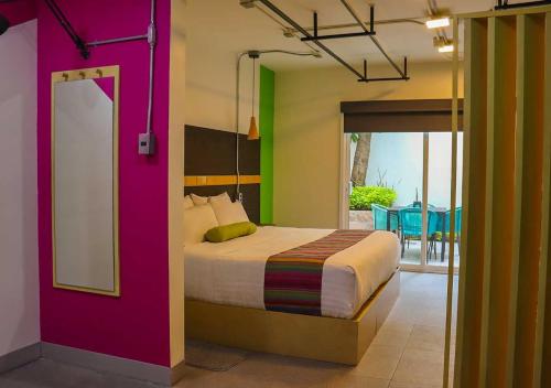a bedroom with a bed with colorful walls at Hotel Estancias VIVE MX wtc CDMX, Trademark by Wyndham in Mexico City