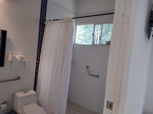a bathroom with a shower with a toilet and a window at Campestre el Salitre Villeta in Villeta