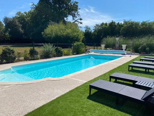- une piscine avec deux bancs dans l'établissement Château de St-fulgent, gîte La Tour, à Saint-Fulgent