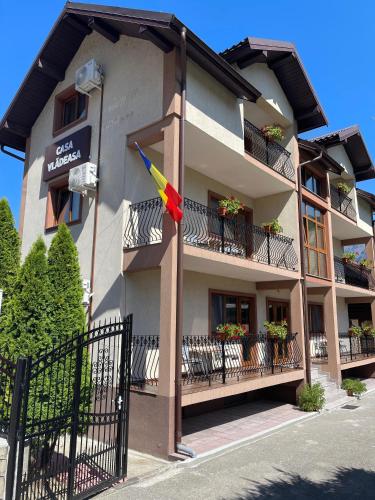 a building with a flag on the side of it at Casa Vladeasa in Caciulata