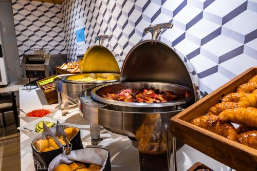 a buffet line with food and pastries on display at Holiday Inn Express Rosario by IHG in Rosario