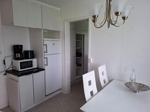a kitchen with a white refrigerator and a white table at Oulaisten mökkeröinen in Oulainen