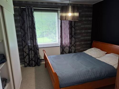 a bedroom with a bed and a window at Oulaisten mökkeröinen in Oulainen