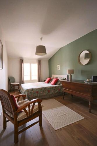 - une chambre avec un lit, une table et un banc dans l'établissement Les chambres de la Dombes, à Pizay