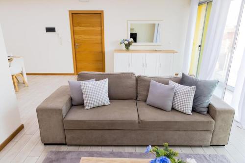 a brown couch with pillows in a living room at Jet Ap & Car 22 in Praia