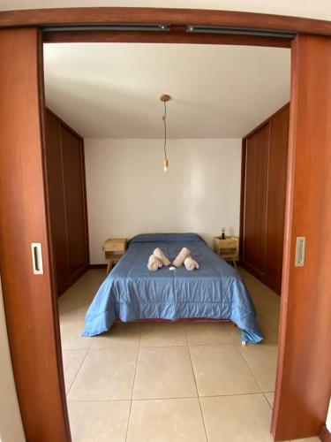 a bedroom with a bed with a blue comforter at Malbec San Juan in Rivadavia