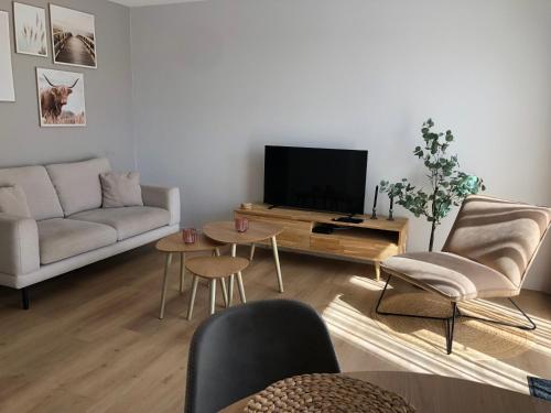 a living room with a couch and a tv at ' Zilten Huus Zoutelande in Zoutelande