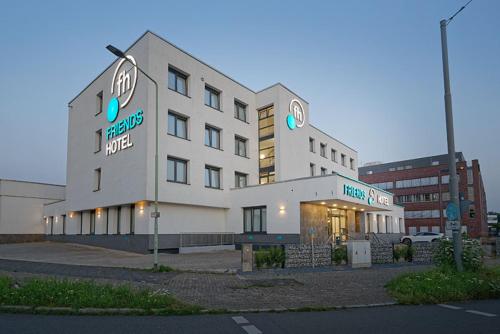a large white building with a sign on it at Friends Hotel Düsseldorf-Airport Ratingen in Ratingen