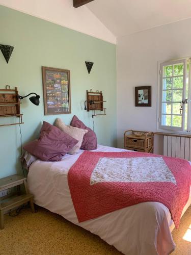 - une chambre avec un grand lit et des oreillers violets dans l'établissement Un joyau caché au bord de la mer, à Saint-Cyr-sur-Mer