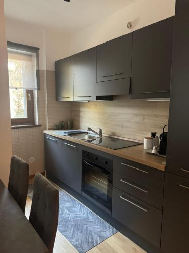 a kitchen with black cabinets and a sink at Casa nel verde di Casal Palocco Roma in Casal Palocco