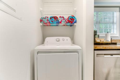 a small white kitchen with a dishwasher and a sink at Upscale St Simons Condo Sunroom and Steps to Pool! in Island Retreat