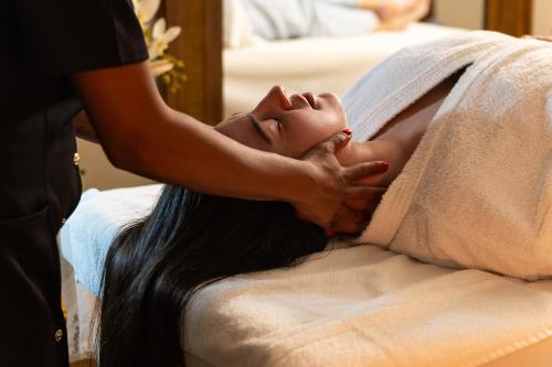 a woman laying on a bed with a towel at Hotel Golden Park All Inclusive Poços de Caldas By Nacional Inn in Poços de Caldas