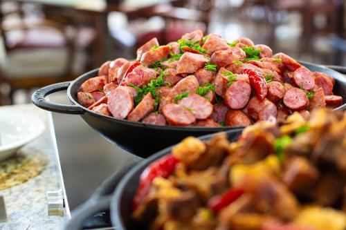 two pans of food sitting on a table at Hotel Golden Park All Inclusive Poços de Caldas By Nacional Inn in Poços de Caldas