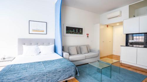 une chambre d'hôtel avec un lit et un canapé dans l'établissement Home At Porto - Aliados Apartments, à Porto