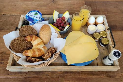 a tray of food with bread and eggs and drinks at Op Het Goede Pad in Veenhuizen
