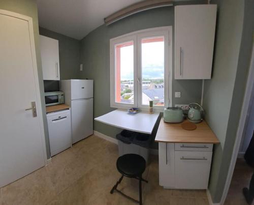 une cuisine avec un comptoir blanc et une fenêtre dans l'établissement l adresse en Bretagne, à Paimpol