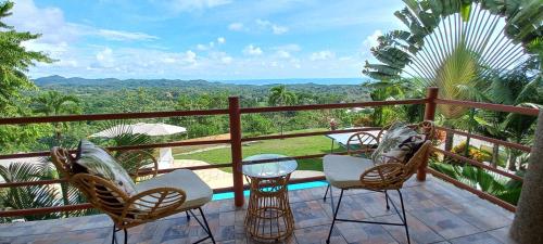 a balcony with chairs and a table and a view at Vista Villas in Ojochal