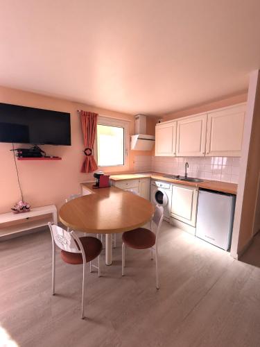 une cuisine avec une table et des chaises dans une cuisine dans l'établissement Studio Marcel D tout confort, à Saint-Vigor-le-Grand