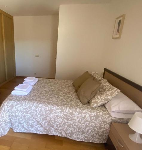 a bedroom with a bed with towels on it at Apartamento Combarro chico in Combarro