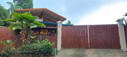 a wooden fence with a gate with a sign on it at Vista Villas in Ojochal