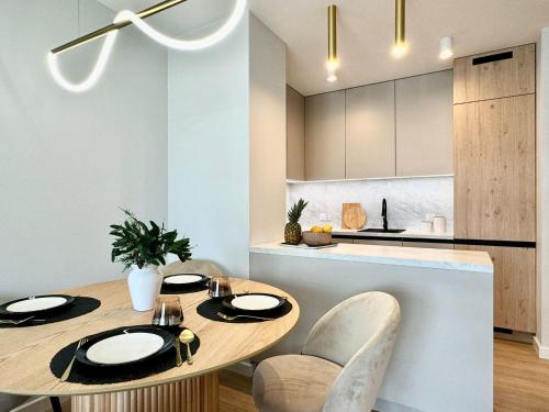a kitchen and dining room with a wooden table and chairs at Jasielska Apartamenty - Komfortowy Nocleg Poznań in Winiary