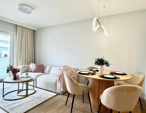 a living room with a couch and a table and chairs at Jasielska Apartamenty - Komfortowy Nocleg Poznań in Winiary