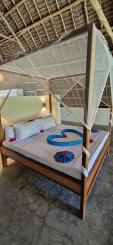 a bedroom with a bunk bed with a canopy at Villa Hunzibar Jambiani in Jambiani