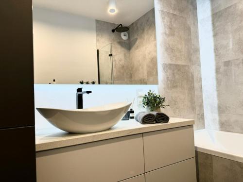 a bathroom with a large bowl sink on a counter at Jasielska Apartamenty - Komfortowy Nocleg Poznań in Winiary