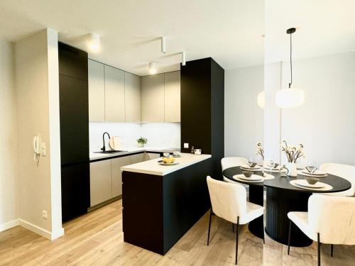 a kitchen and dining room with a table and chairs at Jasielska Apartamenty - Komfortowy Nocleg Poznań in Winiary