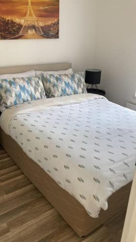 a bed with a white comforter in a bedroom at Centrally located 2 bedroom house with garden in Omagh