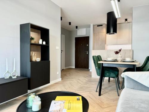 a living room with a table and a dining room at Jasielska Apartamenty - Komfortowy Nocleg Poznań in Winiary