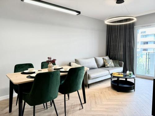 a living room with a table and a couch at Jasielska Apartamenty - Komfortowy Nocleg Poznań in Winiary