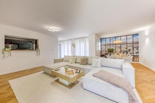 a living room with a white couch and a table at Villa Familiale Piscine Jaccuzi Entre Disney et Paris in Rosny-sous-Bois
