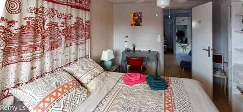 a bedroom with a bed with a red chair at joli appartement in Villeneuve-sur-Lot