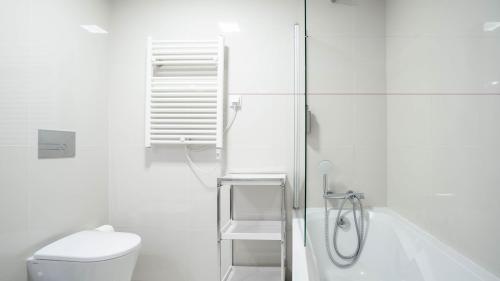 une salle de bain blanche avec douche et toilettes dans l'établissement Home At Porto - Aliados Apartments, à Porto