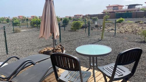 a patio with a table and chairs and an umbrella at Villa Punta Calma in Majanicho