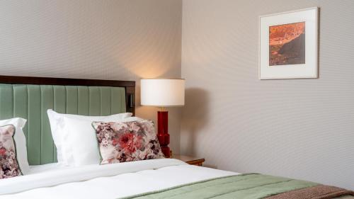 a bedroom with a bed and a lamp on a table at Ballymascanlon Hotel and Golf Resort in Dundalk