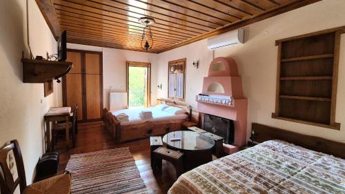 a room with two beds and a table in a room at Traditional Guesthouse Marousio in Rodavgi