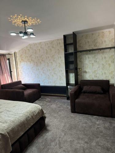 a bedroom with a bed and a couch and a shelf at Nino Ratiani's Guesthouse in Mestia