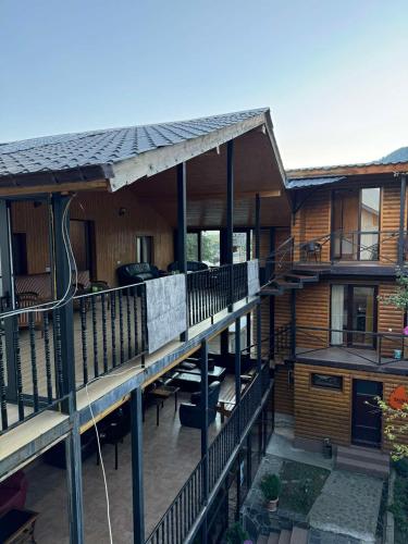 a wooden house with a deck and a patio at Nino Ratiani's Guesthouse in Mestia
