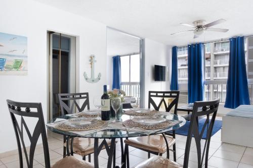 a dining room with a glass table and chairs at Playa Escondida Oceanview Pool Parking 1BDR in San Juan
