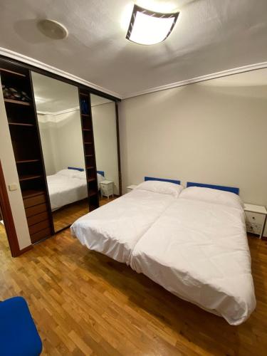 a bedroom with a large white bed and a mirror at Alojamiento turístico en el centro de Logroño in Logroño