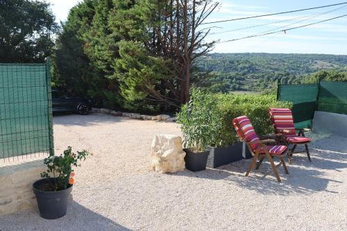 a patio with two chairs and some plants at Les Vignes du Luberon in Saignon