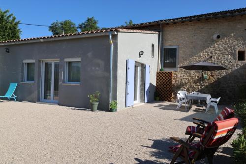 a patio with a table and chairs and a building at Les Vignes du Luberon in Saignon