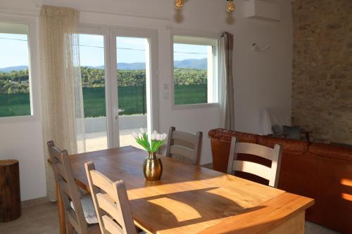 a dining room table with a vase of flowers on it at Les Vignes du Luberon in Saignon