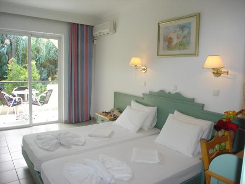 a bedroom with a bed with two white towels on it at Andromeda Hotel Apartments in Kos Town
